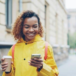 Pilot community member with a coffee, checking her phone
