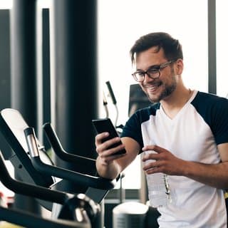 Pilot community member smiling at his phone after a workout